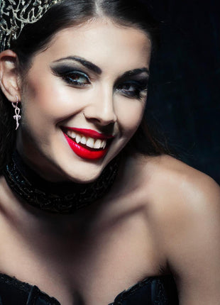 Leonor is wearing 2nd Generation Legacy Ankh Earrings in Rhodium Plated  925 Silver. She's wearing Classic Canines 3D Printed Fangs by Sabretooth Fangs.